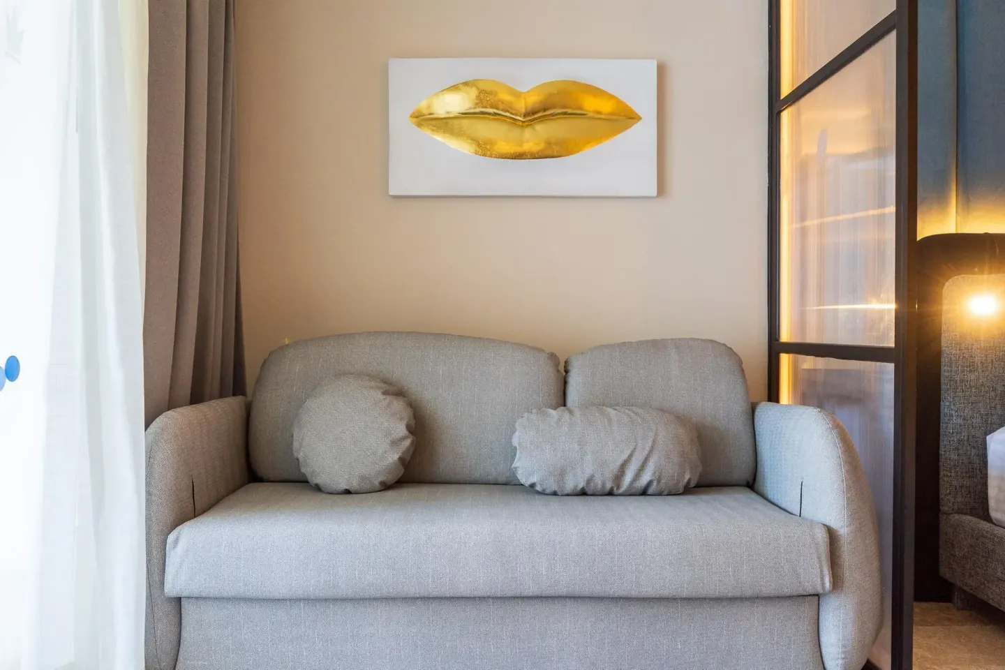Guest room sofa with pillows and gold lip artwork at Grand Riviera Princess.
