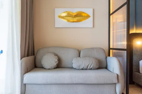 Guest room sofa with pillows and gold lip artwork at Grand Riviera Princess.