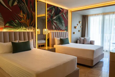 Guest room with two double beds and tropical wall panels at Grand Riviera Princess.