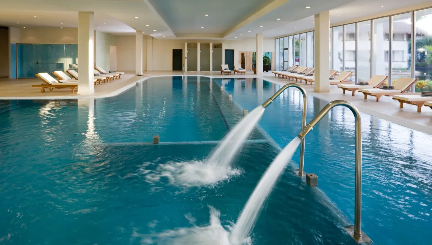 Indoor pool with water jets and lounge chairs at Grand Riviera Princess.