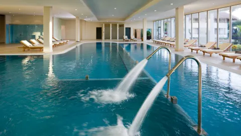 Indoor pool with water jets and lounge chairs at Grand Riviera Princess.