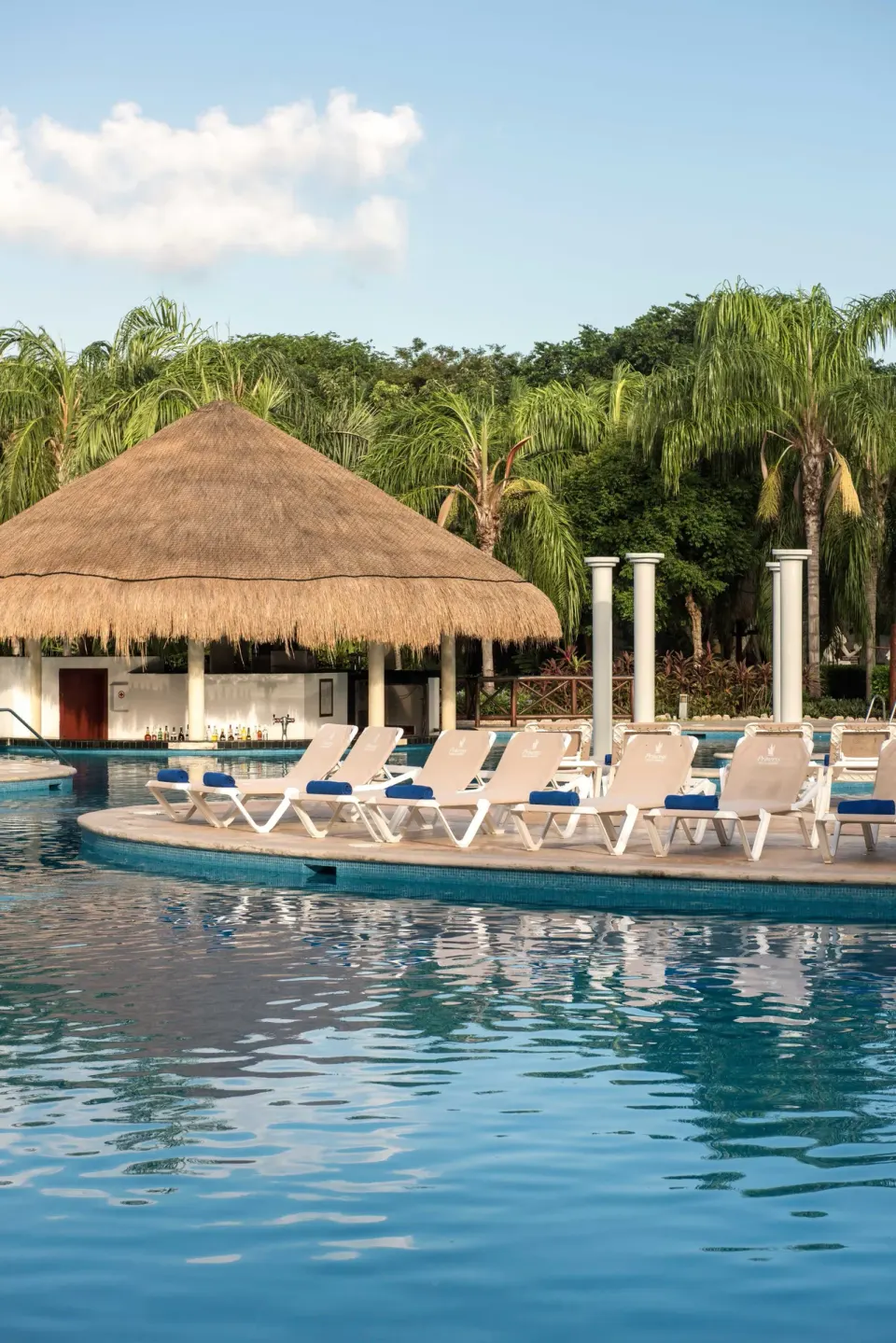 Pool loungers face a thatched swim-up bar area at Grand Riviera Princess.