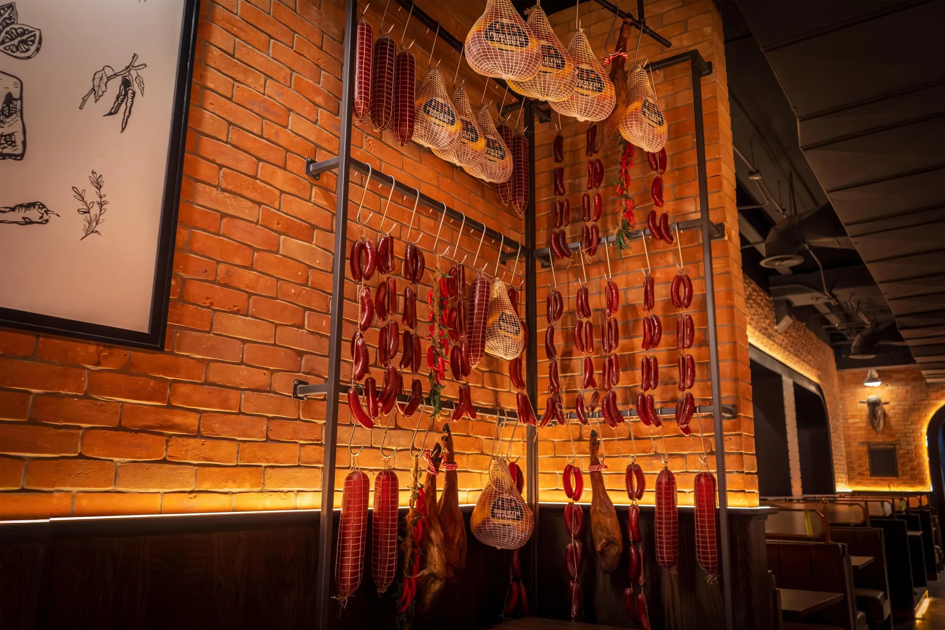 Brick steakhouse wall with hanging sausages and cured meats at Grand Riviera Princess.