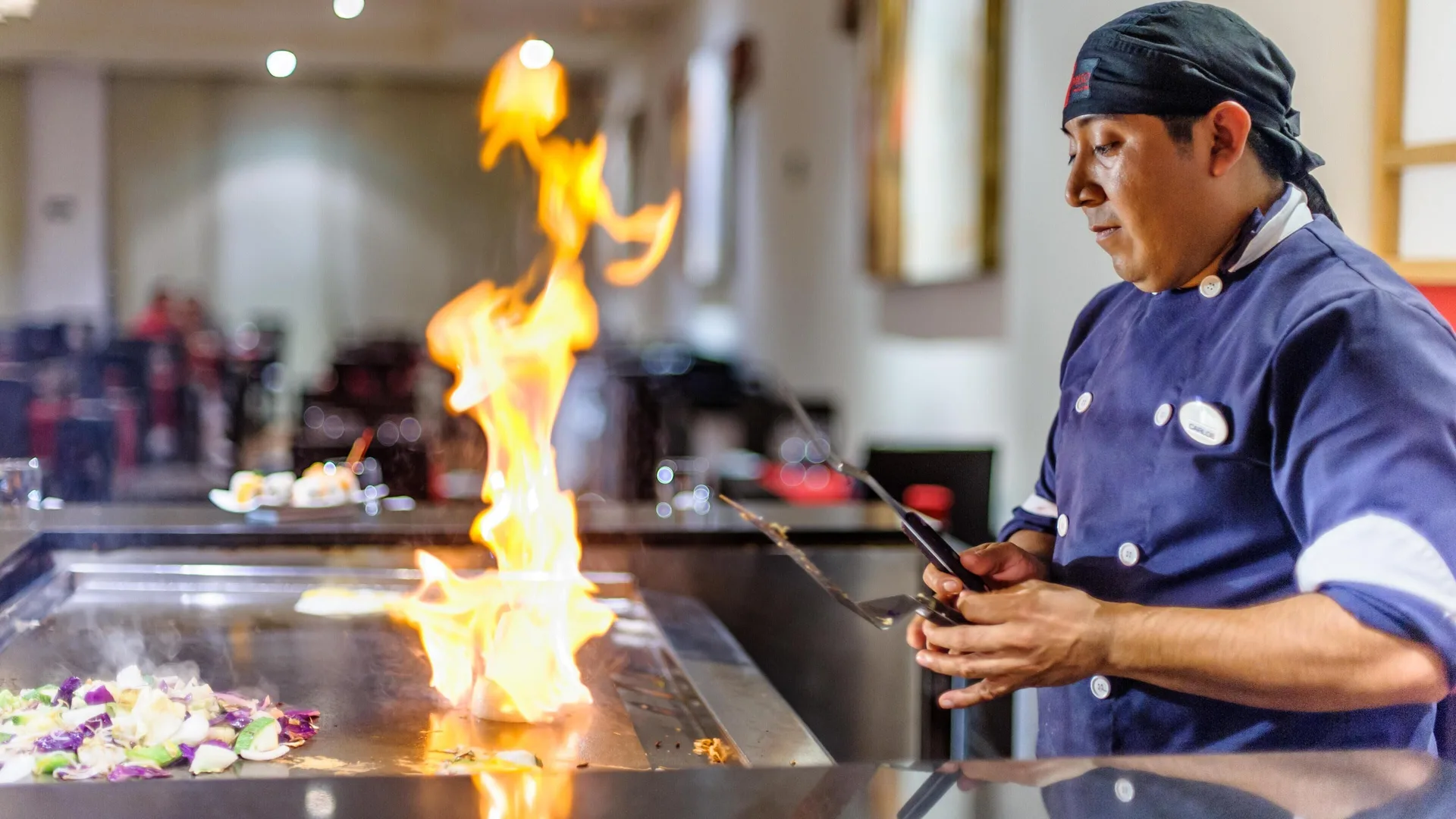 Chef cooking with flames on a flat-top grill at Grand Riviera Princess.
