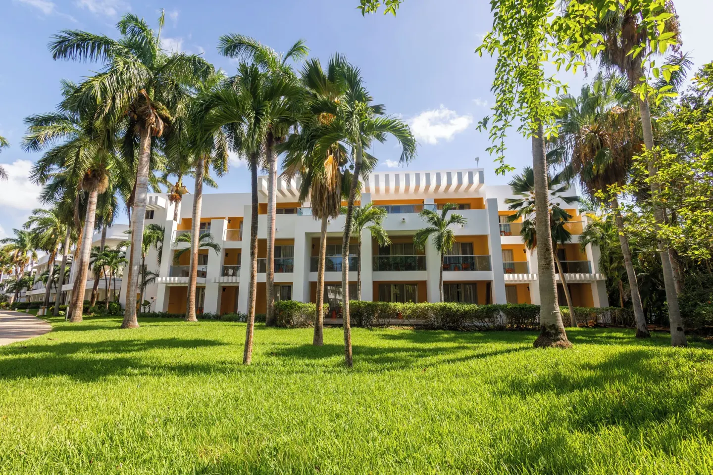 Family Club Deluxe building exterior with palm trees at Grand Riviera Princess.