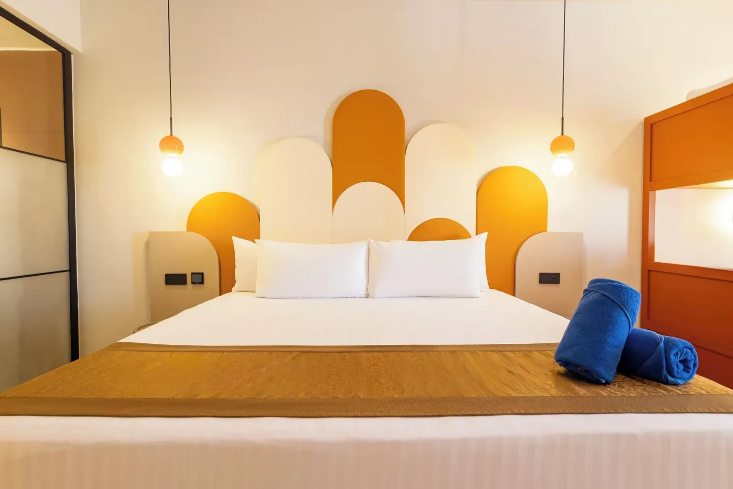 Family Club Deluxe king bed with orange headboard accents at Grand Riviera Princess.