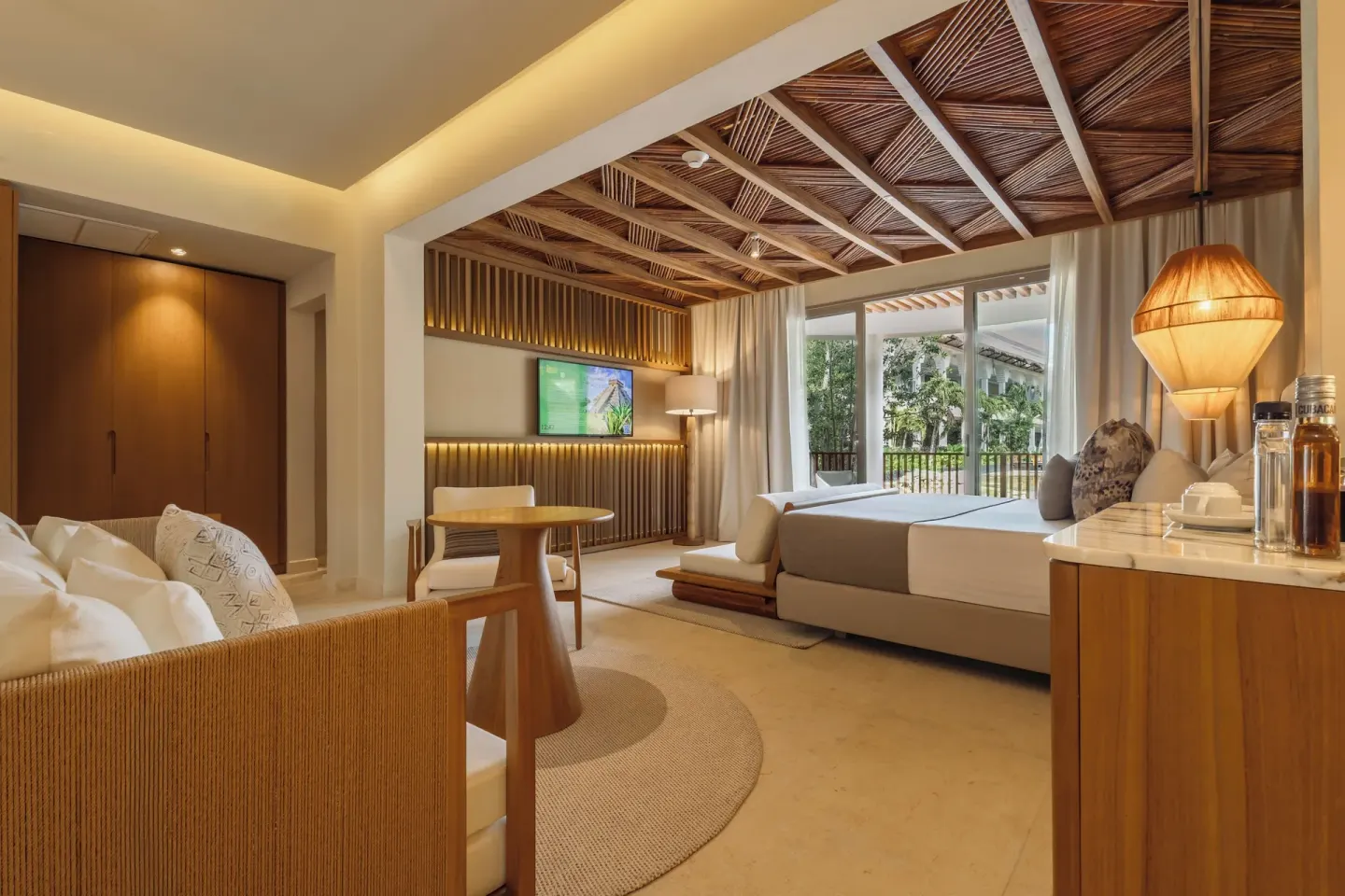 Laguna Villa Suite king bed, lounge area, and balcony view at Grand Riviera Princess.