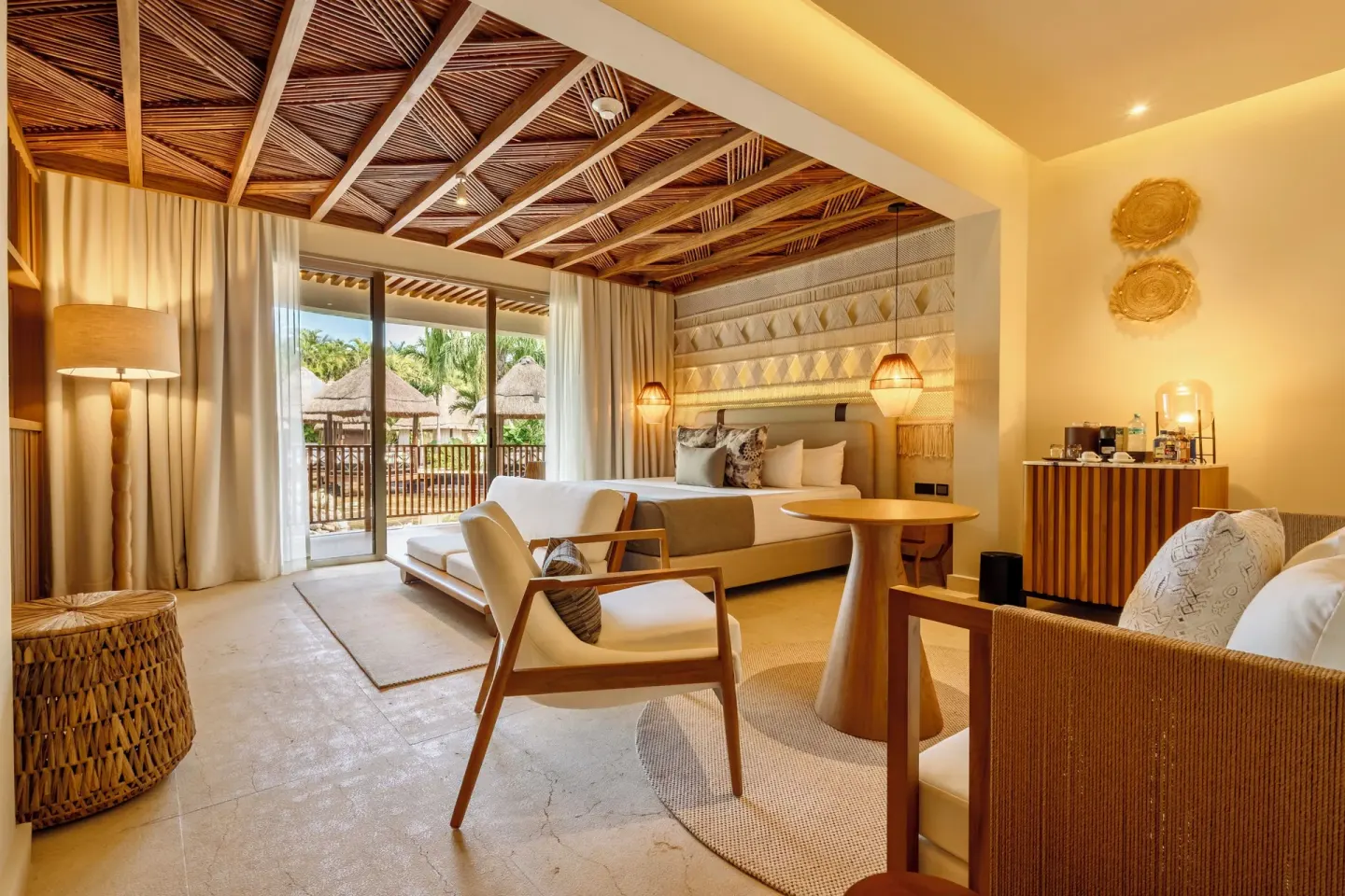Laguna Villa Suite king bed and lounge chairs by balcony doors at Grand Riviera Princess.