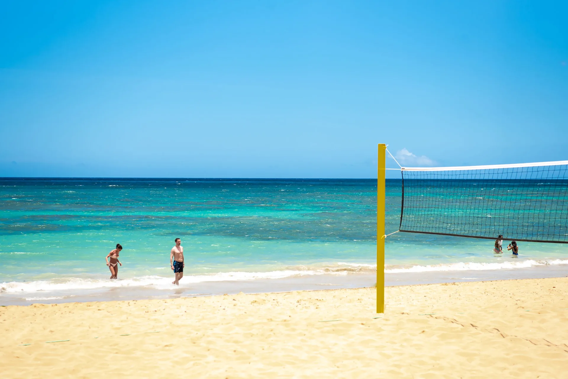 Beach volleyball net by turquoise water at Grand Sirenis Punta Cana Resort & Aquagames.