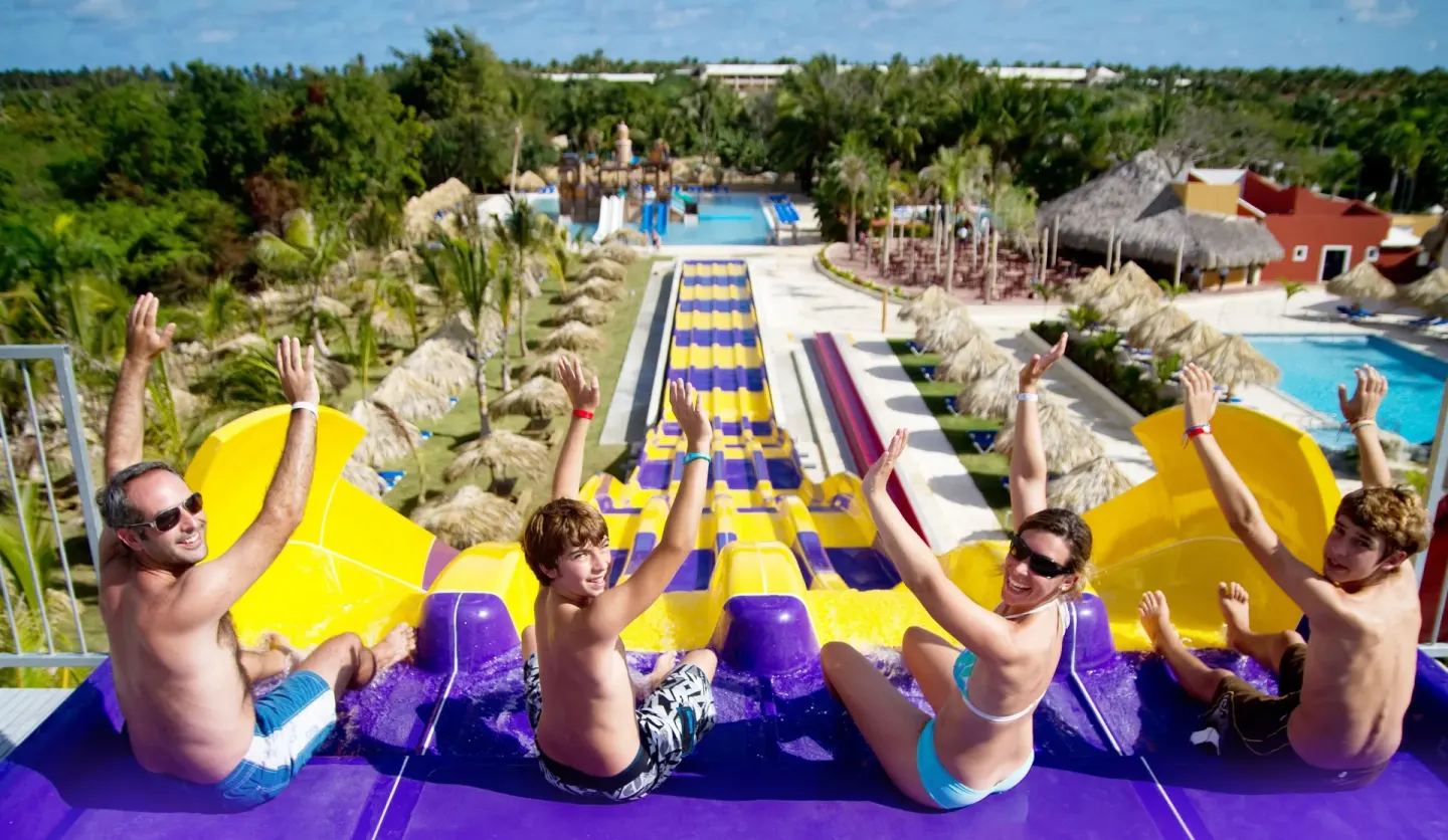 Family at the top of a multi-lane water slide at Grand Sirenis Punta Cana Resort & Aquagames.