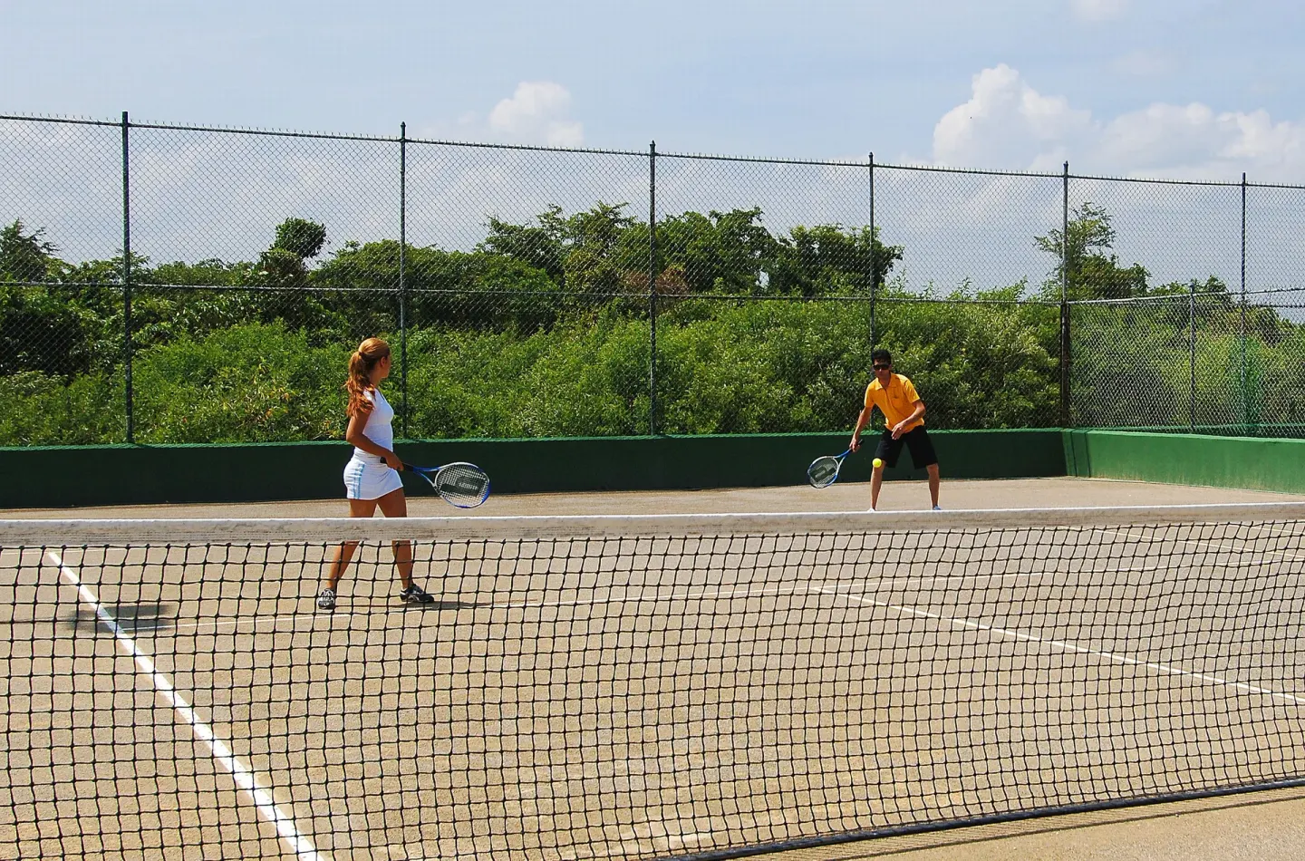 Guests playing tennis on an outdoor court at Grand Sirenis Punta Cana Resort & Aquagames.