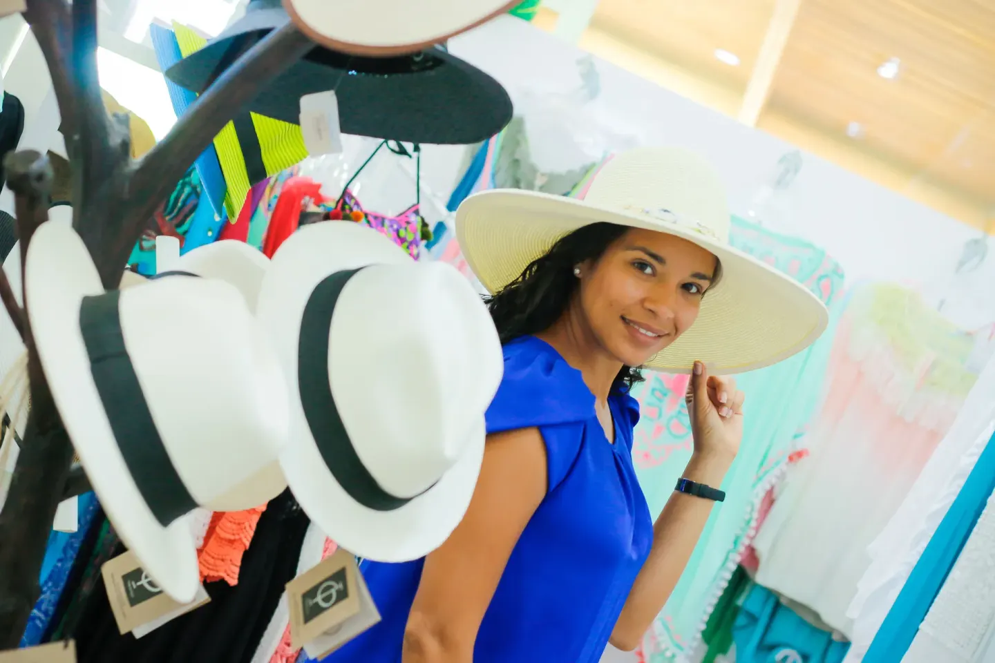 Guest trying on a wide-brim hat in a shop at Grand Sirenis Punta Cana Resort & Aquagames.