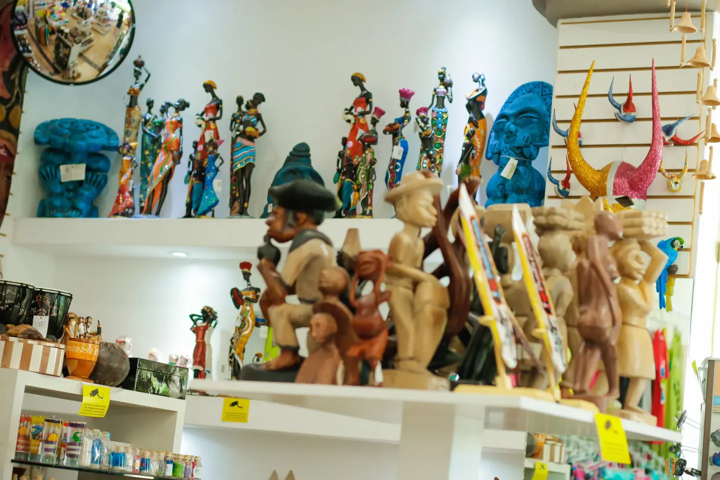 Carved figures and colorful souvenirs on shop shelves at Grand Sirenis Punta Cana Resort & Aquagames.