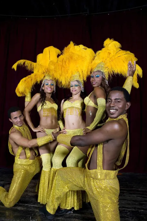 Stage performers in yellow feathered costumes at Grand Sirenis Punta Cana Resort & Aquagames.
