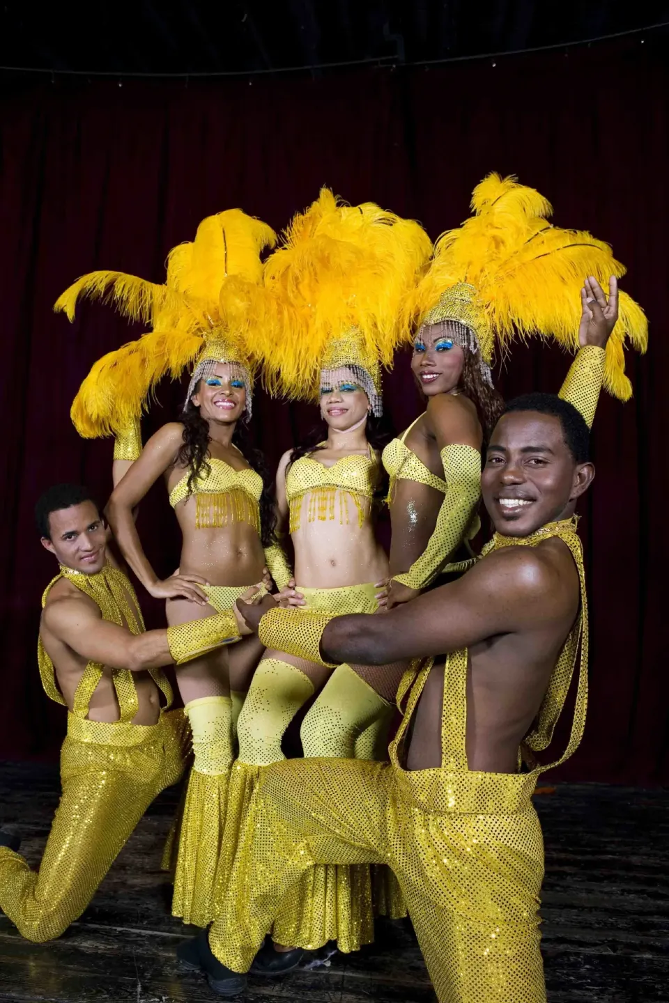 Stage performers in yellow feathered costumes at Grand Sirenis Punta Cana Resort & Aquagames.