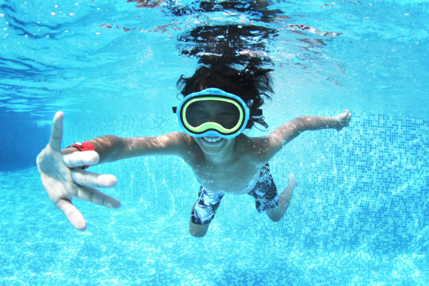 Child swimming underwater with goggles at Grand Sirenis Punta Cana Resort & Aquagames.