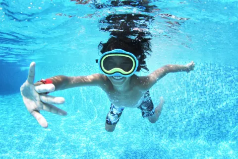Child swimming underwater with goggles at Grand Sirenis Punta Cana Resort & Aquagames.