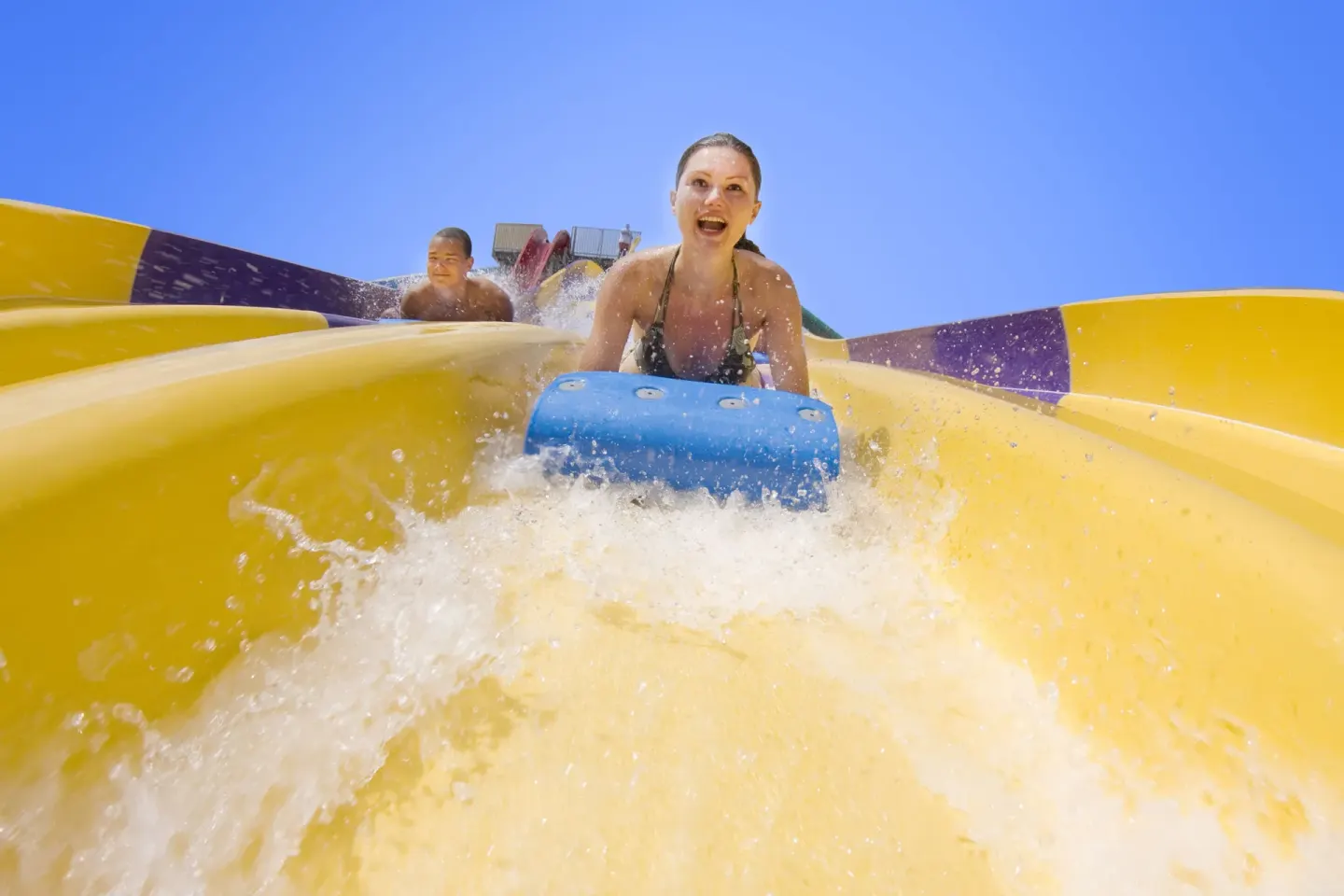 Guests riding a yellow water slide at Grand Sirenis Punta Cana Resort & Aquagames.