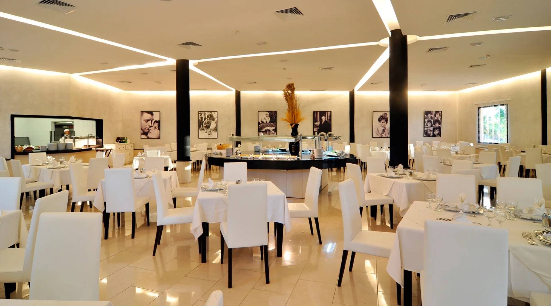 Bright dining room with white chairs and buffet at Grand Sirenis Punta Cana Resort & Aquagames.