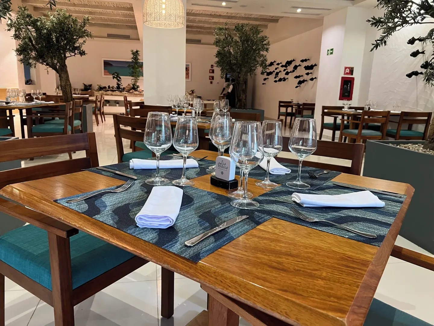Set wooden restaurant table with wine glasses at Grand Sirenis Punta Cana Resort & Aquagames.