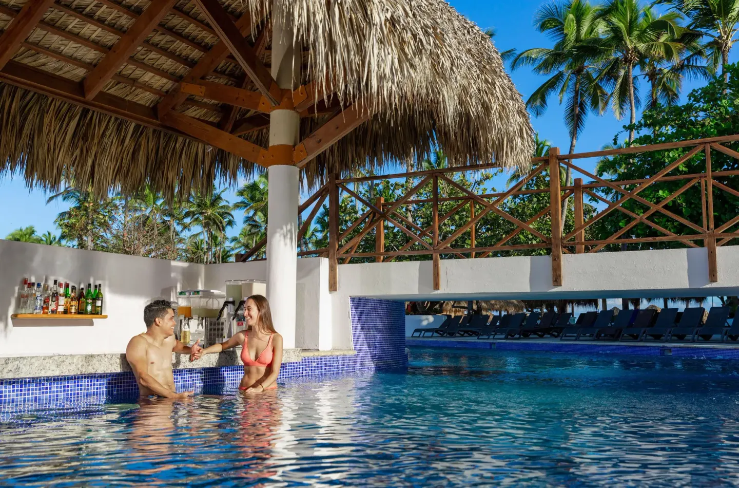 Guests at a swim-up pool bar at Grand Sirenis Punta Cana Resort & Aquagames.