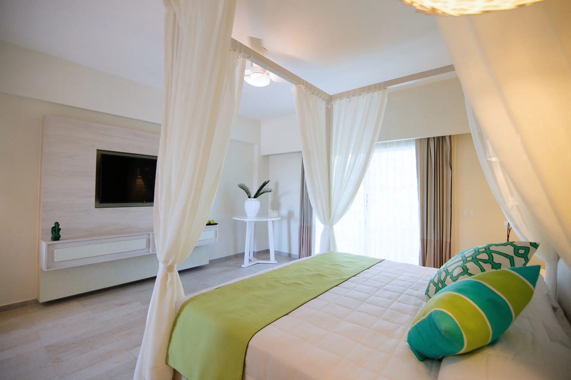 Romantic Room bed with sheer canopy and wall TV at Grand Sirenis Punta Cana Resort & Aquagames.