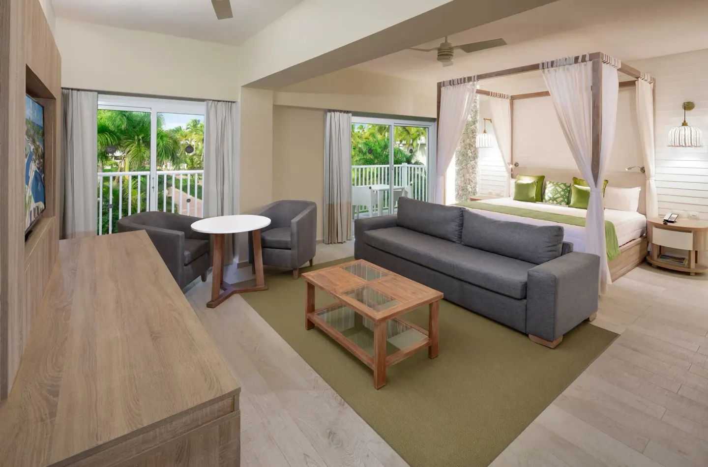 Renovated suite with balcony doors and canopy bed at Grand Sirenis Punta Cana Resort & Aquagames.