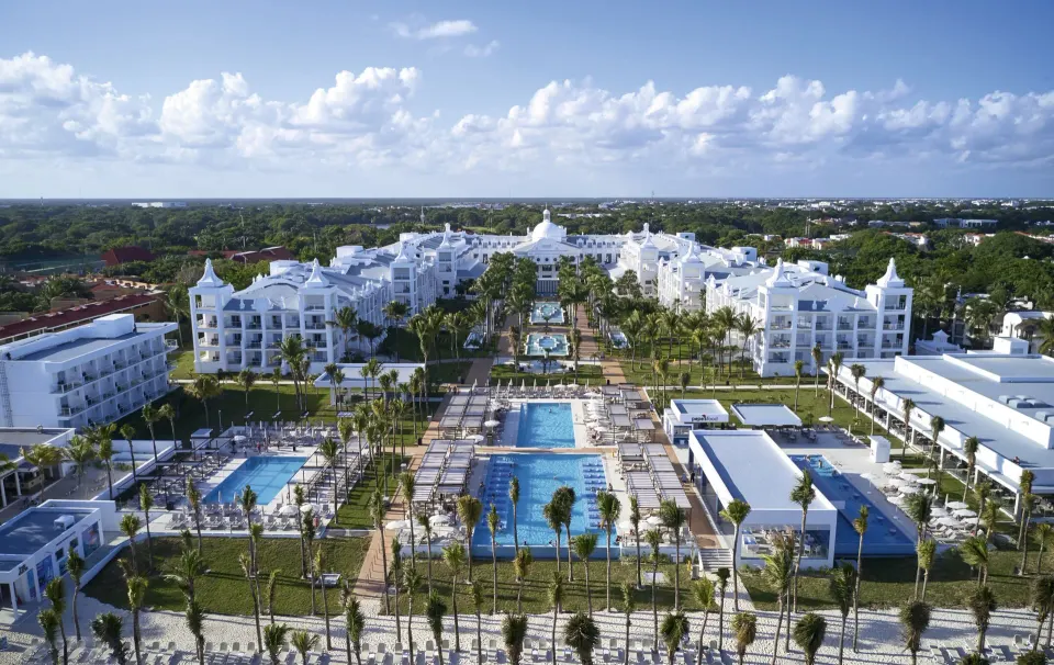 Hotel Riu Palace Riviera Maya popular all-inclusive resort in Playacar with white colonial-style facade and beachfront pool in Playa del Carmen, Mexico.