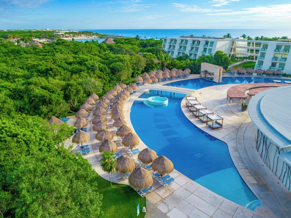 Aerial view of the main resort swimming pool and palapas at Grand Sirenis Riviera Maya Resort & Spa