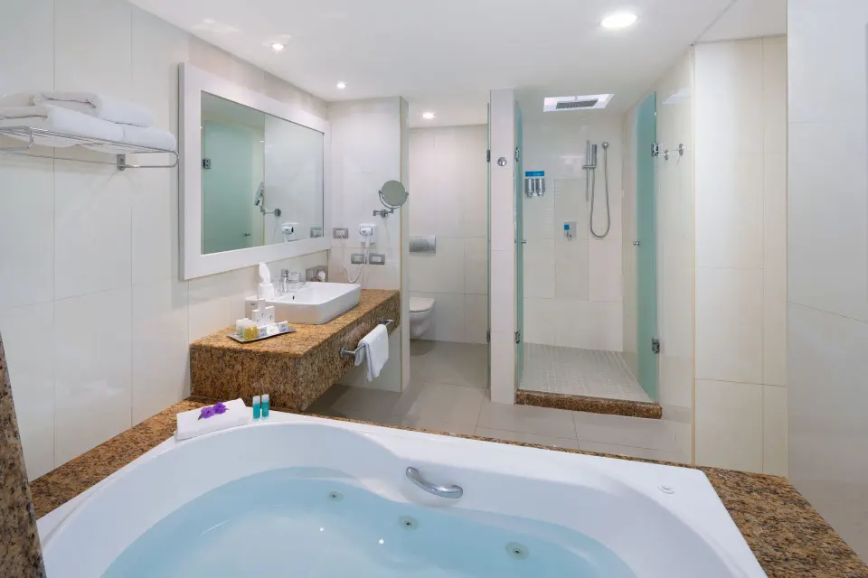 Filled jetted tub with vanity and walk-in shower in a guest bathroom at Grand Sirenis Riviera Maya Resort & Spa