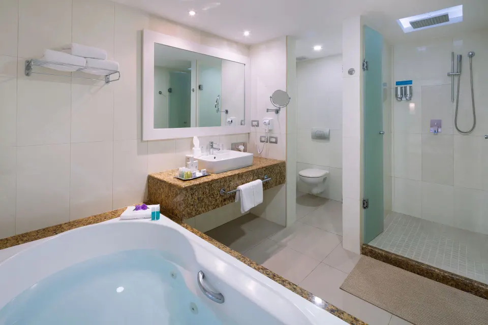 Bright suite bathroom with jetted tub, sink and glass shower at Grand Sirenis Riviera Maya Resort & Spa
