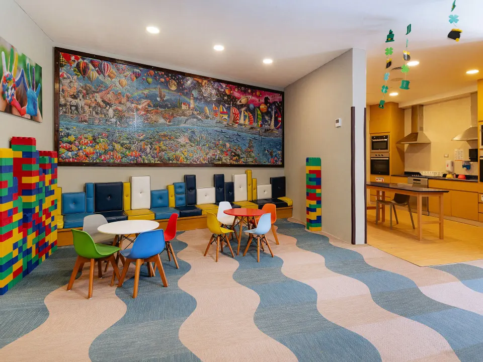 Bright kids' playroom with small tables, colorful chairs and a kitchenette area at Grand Sirenis Riviera Maya Resort & Spa