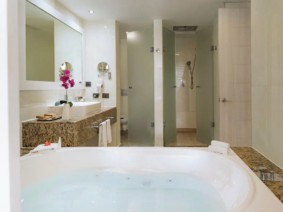Spa-like bathroom with dual shower stalls and orchid detail at Grand Sirenis Riviera Maya Resort & Spa