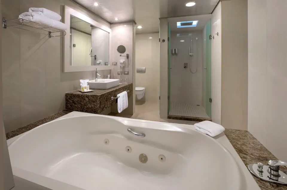 Close-up of jetted tub and shower area in a suite bathroom at Grand Sirenis Riviera Maya Resort & Spa