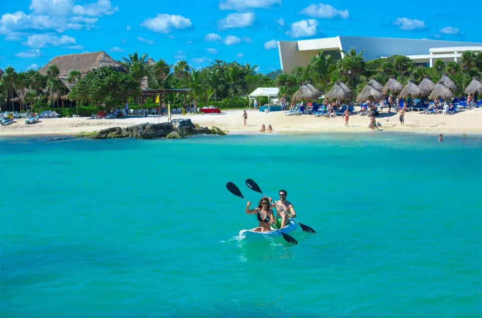 Three people kayaking on turquoise water off the beach at Grand Sirenis Riviera Maya Resort & Spa