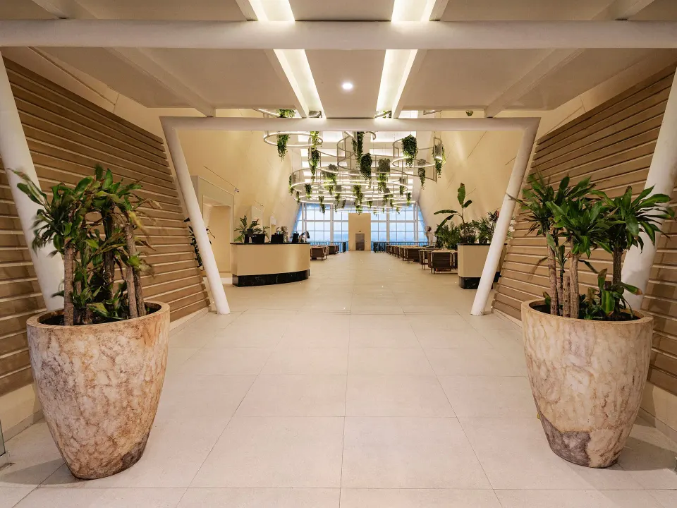 Lobby entry framed by large planters and stairs at Grand Sirenis Riviera Maya Resort & Spa
