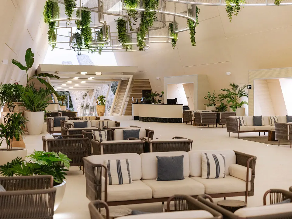 Lobby seating area with sofas and hanging planters at Grand Sirenis Riviera Maya Resort & Spa
