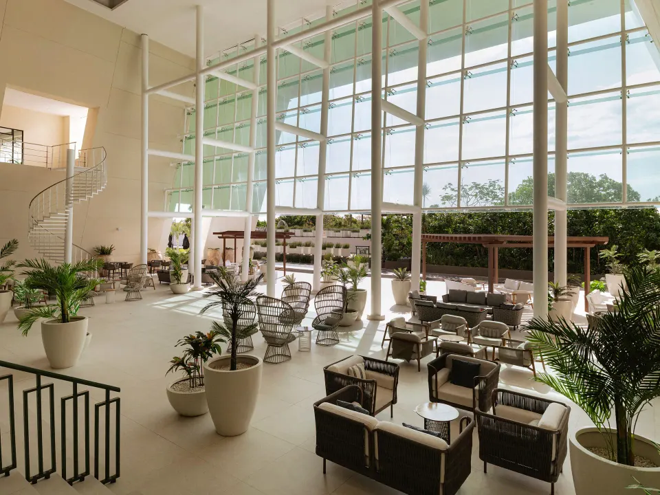 Bright airy lobby seating area with floor-to-ceiling windows at Grand Sirenis Riviera Maya Resort & Spa