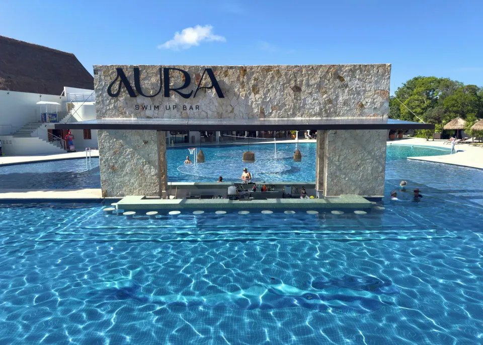 Swim-up bar structure labeled Aura over the pool at Grand Sirenis Riviera Maya Resort & Spa