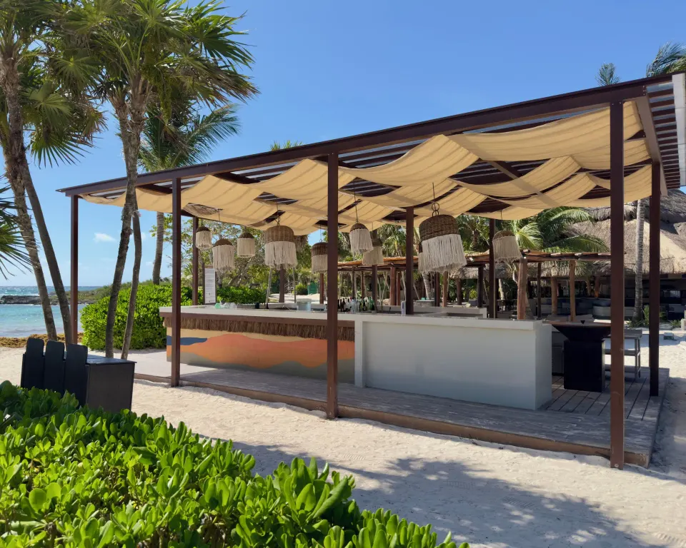 Shaded beach bar with woven pendant lights at Grand Sirenis Riviera Maya Resort & Spa