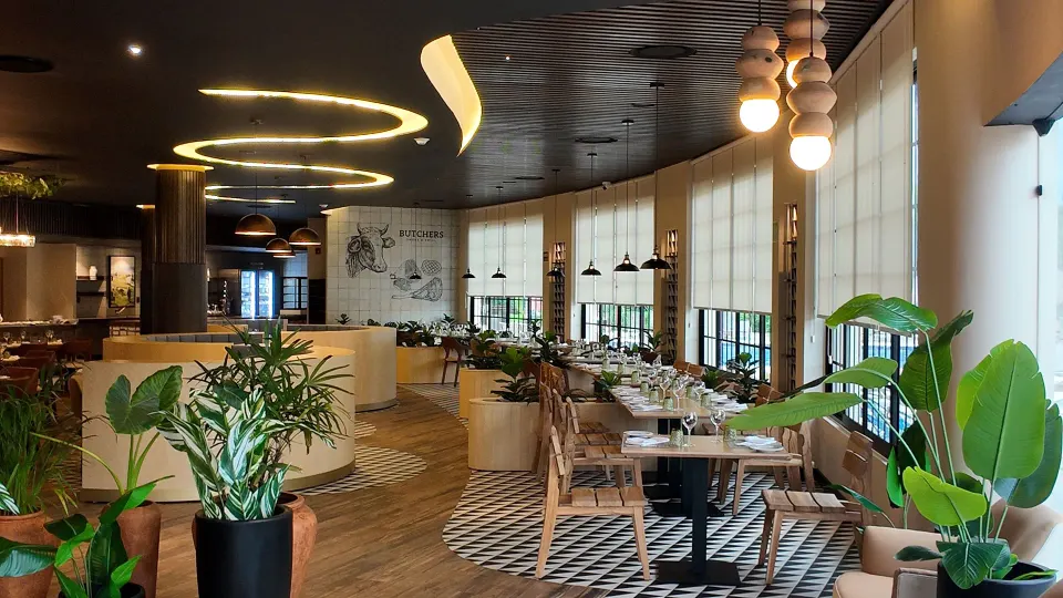 Bright restaurant interior with mixed seating and floor plants at Grand Sirenis Riviera Maya Resort & Spa