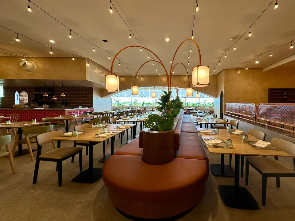 Spacious restaurant interior with central banquette and warm lighting at Grand Sirenis Riviera Maya Resort & Spa