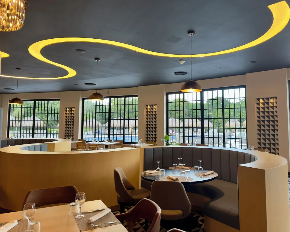 Curved booth seating under decorative ceiling lighting at Grand Sirenis Riviera Maya Resort & Spa