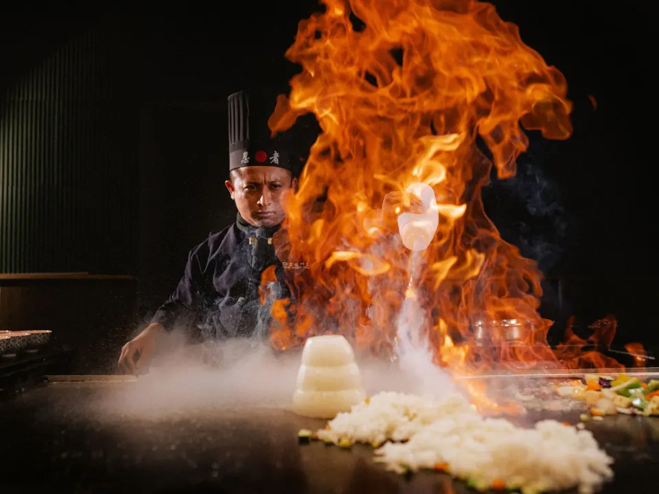 Teppanyaki chef performing a large flame on the grill at Grand Sirenis Riviera Maya Resort & Spa