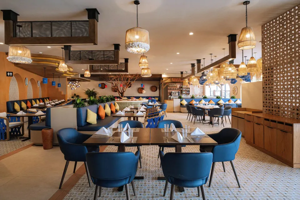 Bright modern dining room with blue chairs at Grand Sirenis Riviera Maya Resort & Spa