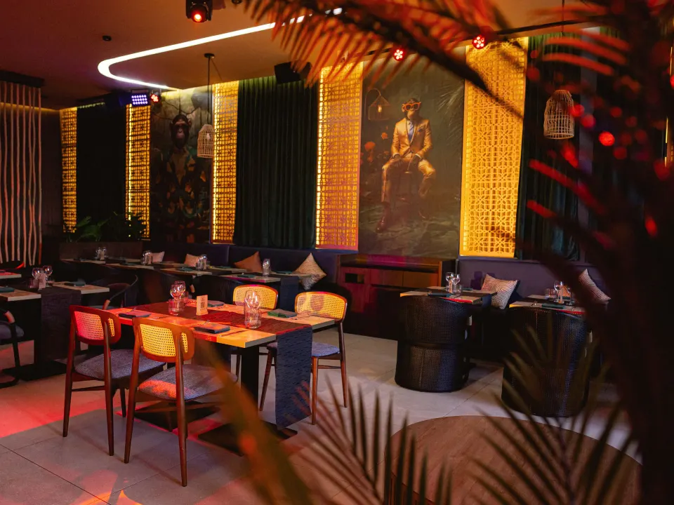 Moody intimate dining space with framed portrait and warm backlighting at Grand Sirenis Riviera Maya Resort & Spa