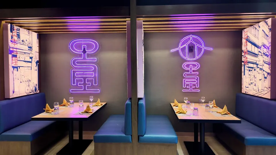 Neon-lit blue booth seating with Japanese-style signs at Grand Sirenis Riviera Maya Resort & Spa
