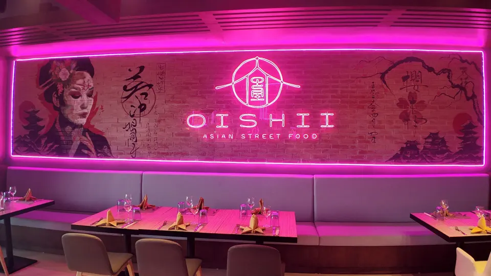 Close-up of Oishii neon wall mural and booth seating at Grand Sirenis Riviera Maya Resort & Spa