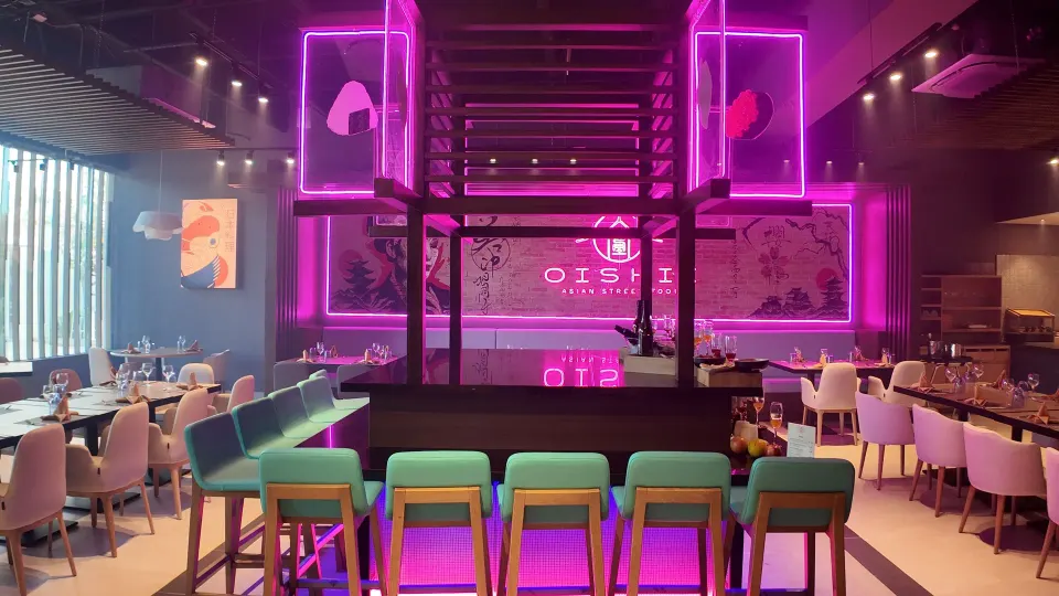 Wide view of Oishii restaurant with bar stools and neon signage at Grand Sirenis Riviera Maya Resort & Spa