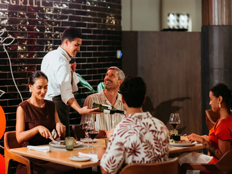 Server pouring wine for a group dining at Grand Sirenis Riviera Maya Resort & Spa